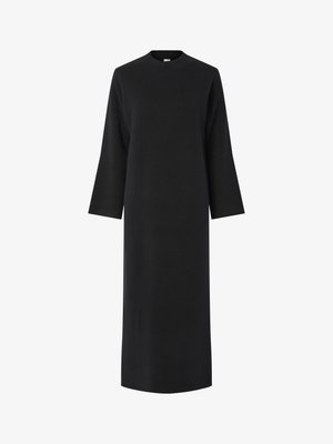 Must mustaga, pikkade varrukatega must kleit kõrge kaelusega, valmistatud siledast ja tekstuurilisest kangast. Omab sirget lõiget ja ulatub üle põlvede.