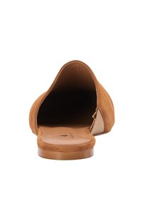 Beige Wildleder-Slipper mit runder Zehenpartie, offenem Fersenbereich und glatter Gummisohle. Strukturierter Schaft mit dezenten Nahtdetails.