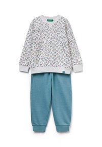 Weißes Sweatshirt mit einem blumigen Muster in Pink und Grün; kombiniert mit petrolfarbenen Jogginghosen mit elastischen Bündchen und Bund.