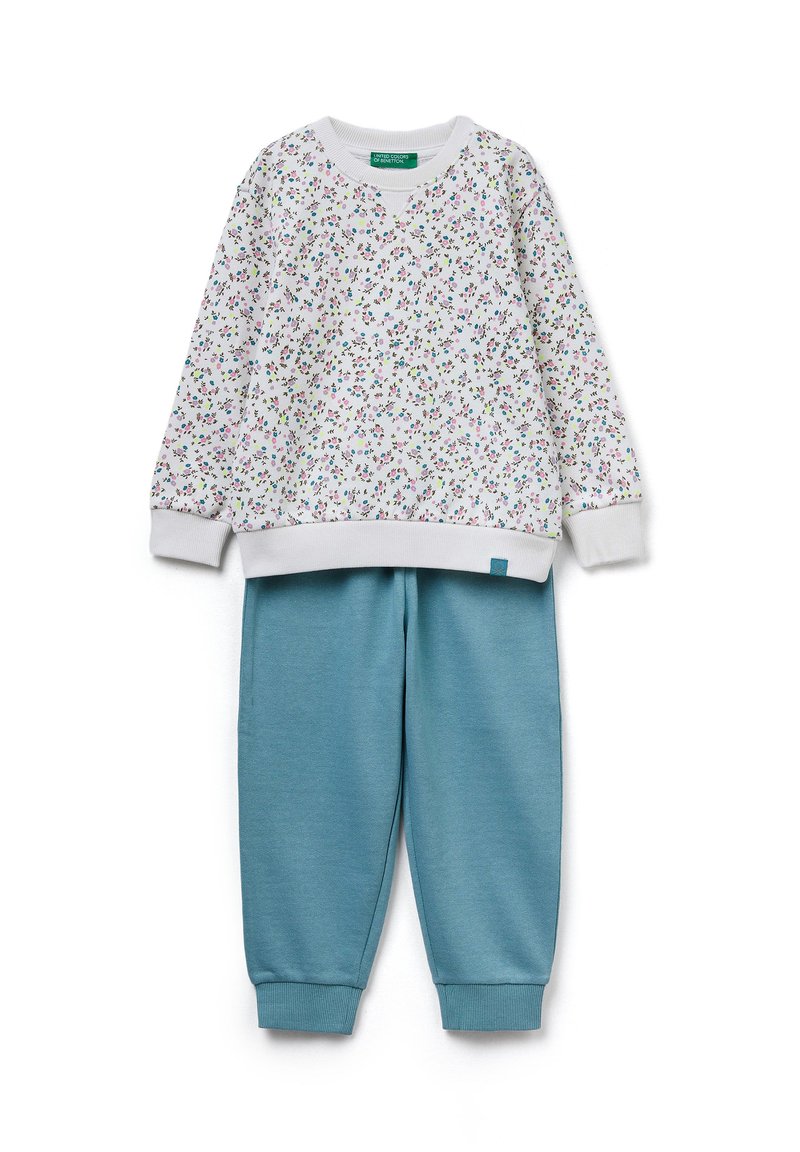 Weißes Sweatshirt mit einem blumigen Muster in Pink und Grün; kombiniert mit petrolfarbenen Jogginghosen mit elastischen Bündchen und Bund.