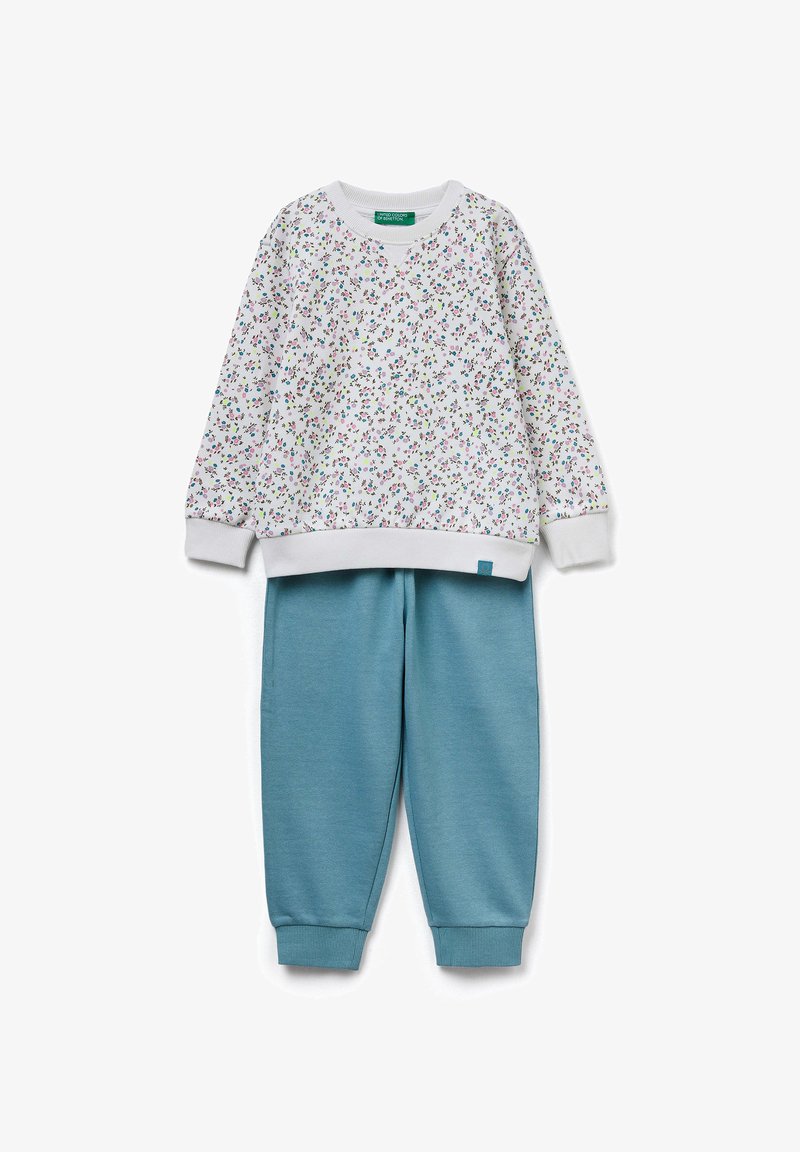 Witte sweatshirt met een bloemmotief in roze en groen; gecombineerd met teal joggingsbroek met elastische boorden en tailleband.