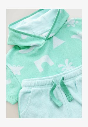 Mintgrön frotté set om två delar, med en huvad kortärmad topp med vita mönster och matchande shorts med elastisk midja.
