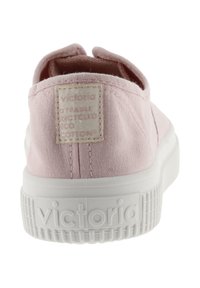 Scarpa in tela rosa con superficie texture, suola in gomma bianca e patch con logo cucito sul retro. Design slip-on senza lacci.