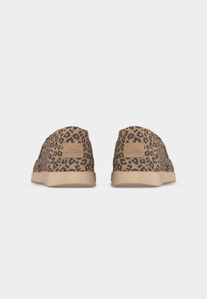 Paire de chaussures à enfiler en tissu imprimé léopard beige et noir avec des semelles en caoutchouc beige, vues de dos.
