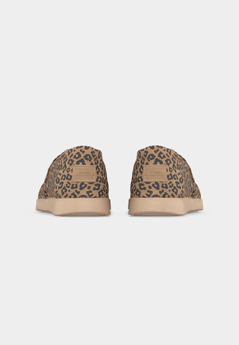 Paire de chaussures à enfiler en tissu imprimé léopard beige et noir avec des semelles en caoutchouc beige, vues de dos.