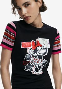 Schwarzes T-Shirt mit kurzen gestreiften Ärmeln in Pink, Rot und Schwarz. Mit einem Grafikdesign von Minnie Mouse, im gepunkteten Kleid und textlichen Akzenten.