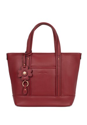 Czerwona torebka na ramię z podwójnymi uchwytami, przednią kieszenią i dołączonym zawieszką w kształcie kwiatu z złotymi akcentami.