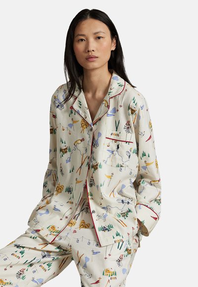 Conjunto de pijama de algodón con fondo crema y patrones coloridos que representan la naturaleza, el esquí y diversas actividades al aire libre. Detalles en ribete rojo.