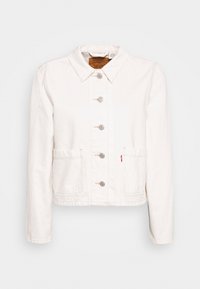 Vit denimjacka med krage, framknäppning med knappar, två framfickor och en liten röd logotagg på vänster ficka.