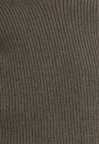 Tkanina ribbed w ciemnym brązie, z pionowymi liniami i miękką teksturą, z delikatnym połyskiem i jednolitym wzorem w całej powierzchni.