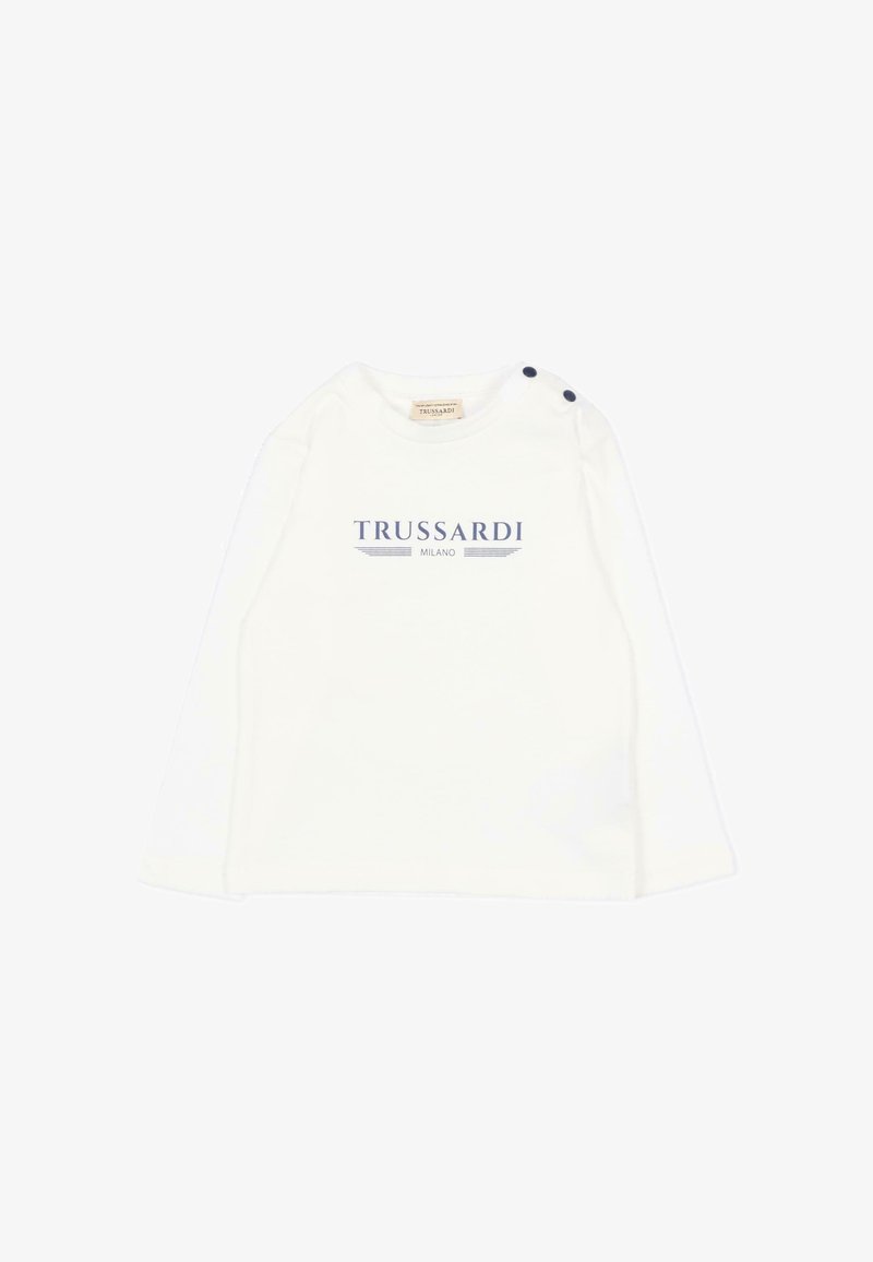 Chemise bébé blanche à manches longues avec le logo « Trussardi Milano » en bleu et deux boutons foncés sur l'épaule gauche.