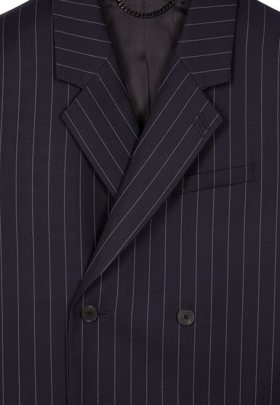 Double-breasted suit jacket in navy fabric with white pinstripes, featuring notched lapels, two black buttons, and a side pocket.