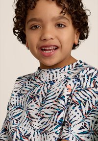 Kortebloesem, gestreepte overhemden met een tropisch loofdesign in wit, blauw en koraal op een zachte stof, aangevuld met een klein logo-detail.