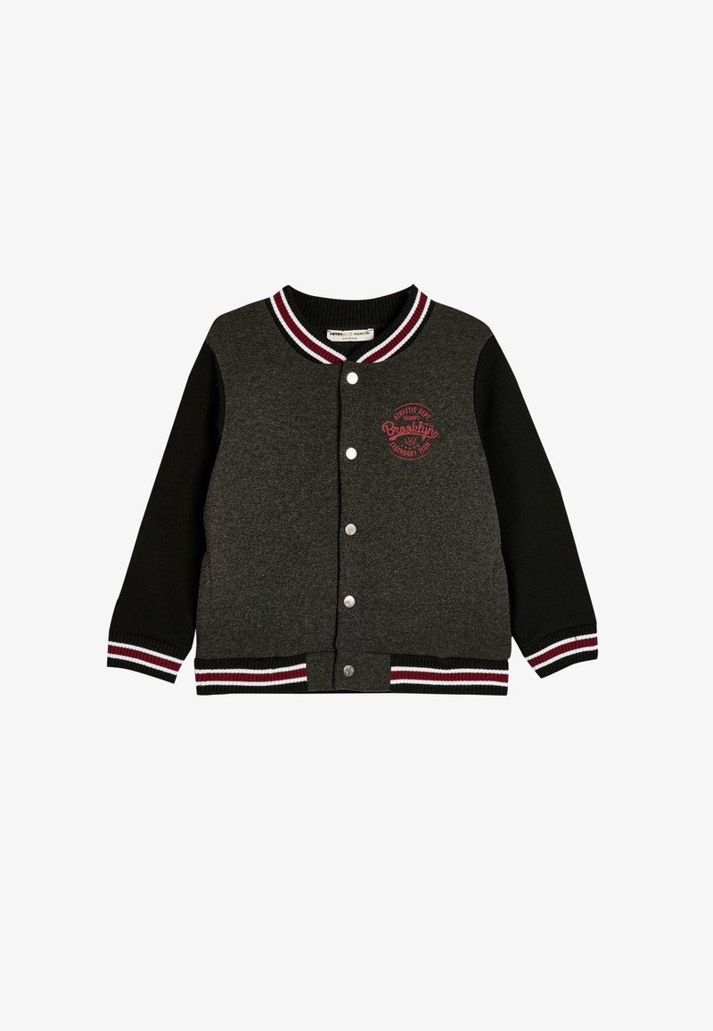 Zwart en grijs varsityjack met geribbelde kraag en manchetten. Voorzien van drukknoopsluiting en een rood "Brooklyn" logo op de borst. Zachte stofstructuur.