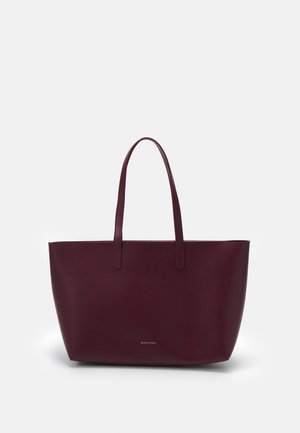 Grote donker bordeauxrode leren tote bag met twee schouderbanden en minimale gouden merktekst aan de voorkant in het midden.