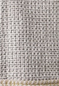 Tkanina zpevněná v světle šedé barvě s texturovaným povrchem, obsahující kovové vlákna a zlatou ozdobnou nit podél spodního okraje.