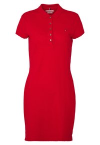 Czerwona sukienka polo wykonana z bawełny, z kołnierzykiem, krótkimi rękawami oraz zapięciem na guziki z pięcioma guzikami. Mały akcent logo na piersi.