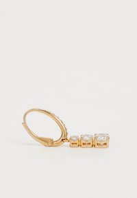 Zlaté kovové náušnice s tromi čírymi zirkónmi v štvrtcových osadeniach, pripevnené na uzávere s pákou s akcentovými kamienkami.