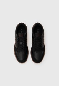 Sorte sneakers laget av syntetisk materiale med en glatt finish, med sorte lisser, teksturerte detaljer og en brun gummisåle.