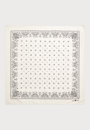 Foulard en coton de couleur crème avec des motifs paisley et floraux noirs, bordé de détails complexes. Présente le logo de la marque dans un coin.