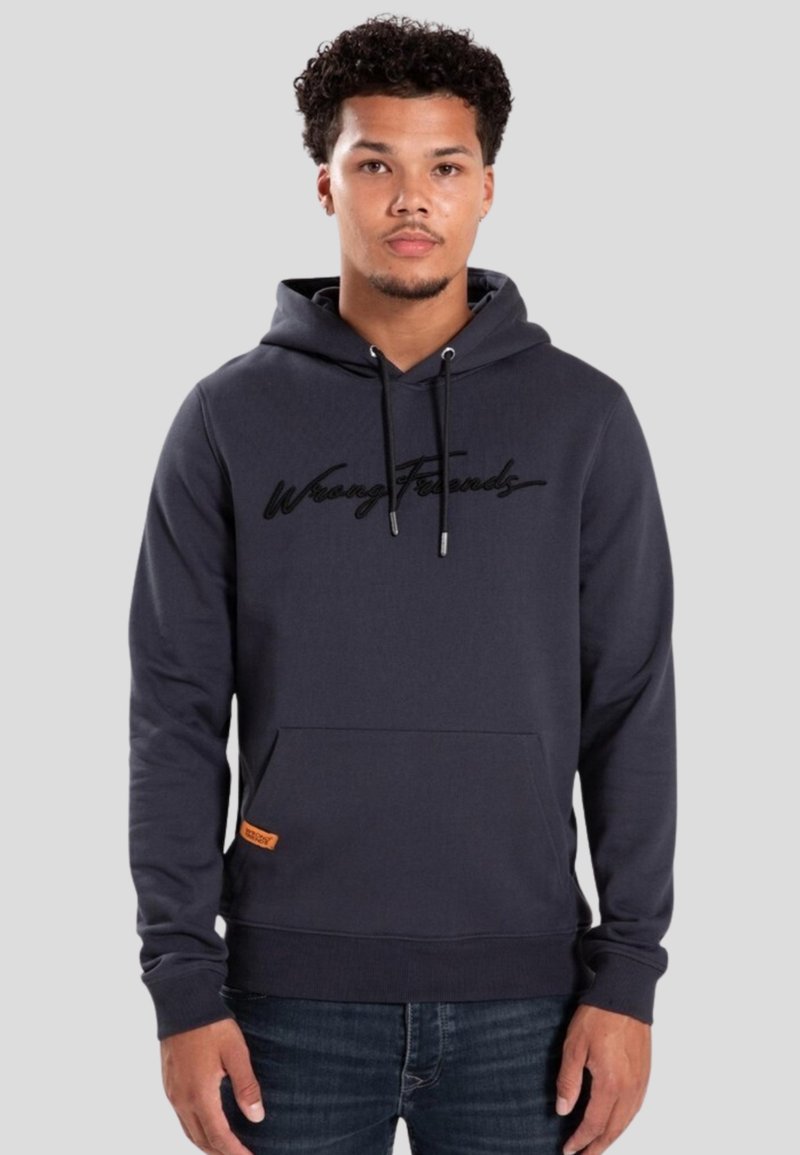 Donkergrijze hoodie met een voorzak, een capuchon met trekkoord en geborduurde "Wrong Friends" letters. Heeft een klein oranje label aan de zijkant.