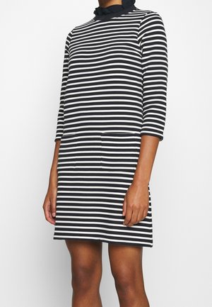 Black and white striped dress with a high neckline, three-quarter sleeves, and two front pockets. Made of soft, textured fabric.