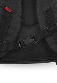 Mochila negra con tela resistente, correas ajustables, un broche de plástico y una pequeña etiqueta roja con el nombre de la marca "JASLEN" adjunta.