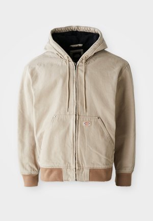 Beige hooded jacket with a zip front, drawstrings, and two front pockets, featuring a contrasting brown ribbed hem and cuffs.