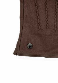 Brown leather glove features textured surface with raised stitching and a branded black metal snap stud. Smooth, soft texture.