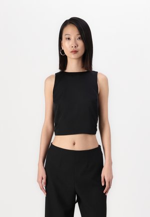 Débardeur noir court avec une texture lisse et un design sans manches, associé à un pantalon noir taille haute. Encolure droite simple.