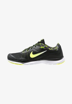 Chaussure de sport Nike noire et jaune néon avec semelle blanche et doublure intérieure à motifs, montrée de côté extérieur.