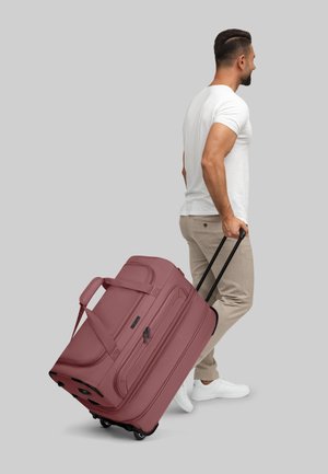 Sac de sport à roulettes en matériau texturé bordeaux, doté de poignées doubles, d'une poignée télescopique et de roues pour un transport facile.