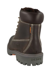 Stivale in pelle marrone con colletto imbottito, cuciture bianche e una suola grigia robusta. Presenta un accento arancione vicino alla linguetta di trazione.