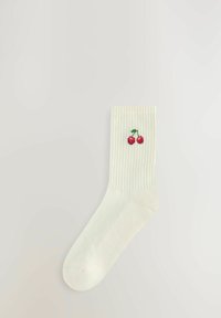 Krämfärgade ribbade strumpor med en broderad körsbärsdesign högst upp. Slät textur, med rundad tå och lätt material.
