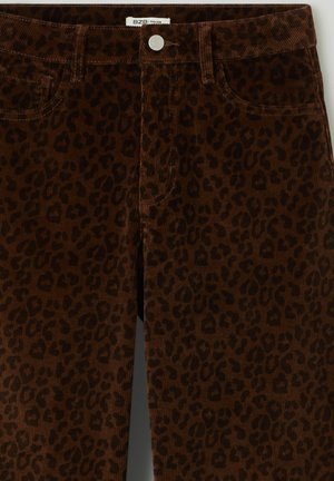 Pantalon en velours côtelé marron avec un motif léopard, des poches avant et une fermeture à bouton métal à la taille.