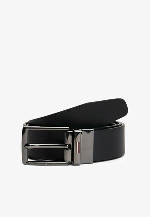 Czarny skórzany pasek z błyszczącą srebrną prostokątną klamrą. Posiada wytłoczone logo oraz paski akcentujące na klamrze. Gładka tekstura.