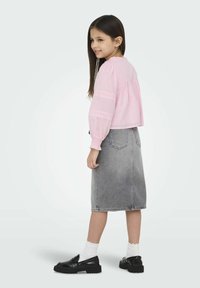 Rosa linblus med puffärmar och spetsdetaljer, i kombination med en grå denimkjol och svarta loafers med tjocka sulor och vita strumpor.