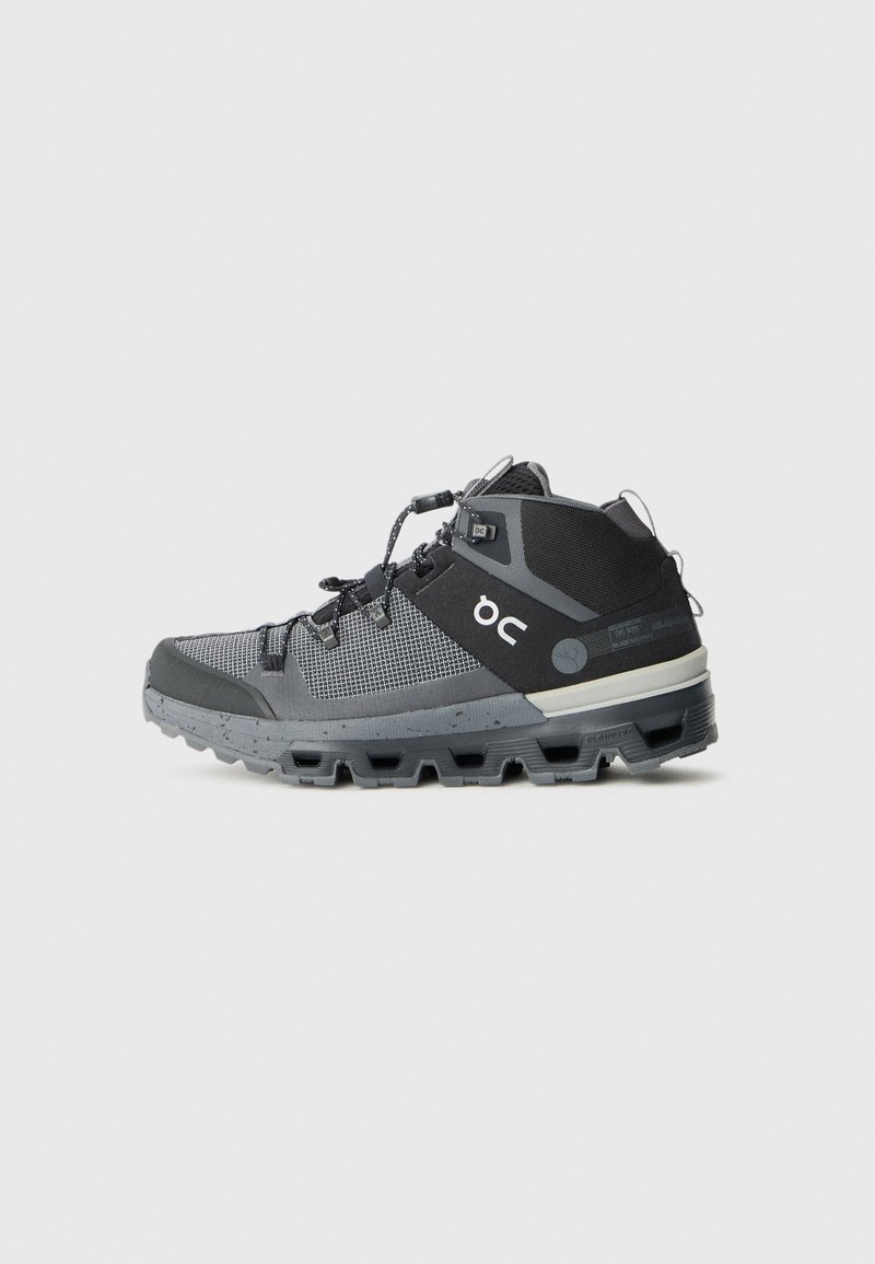 Hochschnittige Trailrunning-Schuhe in Schwarz und Grau. Verfügen über ein atmungsaktives Mesh-Obermaterial, eine geformte Gummisohle mit aggressivem Profil und reflektierenden Akzenten.