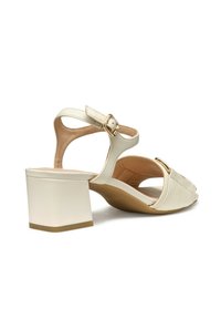 Sandalias de tacón bloque en color crema con una parte superior de cuero texturizado, una correa ajustable y un acento de hardware en tono dorado.