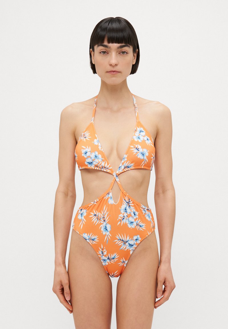 Bikini de flores laranja com copas triangulares, centro recortado e pernas altas. Apresenta um padrão floral azul e alças finas. Textura suave.