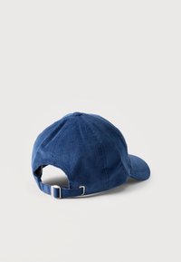 Μπλε καπέλο baseball από κορντορόι με ρυθμιζόμενο λουρί και μεταλλικό κουμπί, εμφανιζόμενο από πίσω πάνω σε απλή λευκή επιφάνεια.