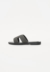 Sorte slidtesandaler med to brede stropper, lavet af stof, med flad sål og minimalistisk design. Glat overfladetekstur.