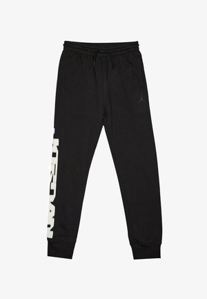 Pantaloni della tuta neri con cintura elastica, tasche laterali e branding bianco lungo la gamba sinistra. Il materiale sembra morbido e texturizzato.