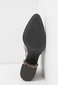 Zapato de tacón alto con punta afilada y parte superior texturizada multicolor, con suela de goma negra antideslizante y un tacón estrecho y elegante.