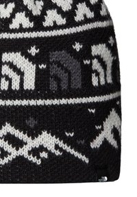 Beanie lavorato a maglia in bianco e nero con motivi montani, fili di spessore diverso e una piccola etichetta con logo sul lato.