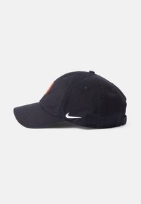 Tamna plava bejzbol kapa od pamuka s zakrivljenim vizorom, koja ima crveni izvezeni logo sprijeda i bijeli Nike swoosh sa strane.