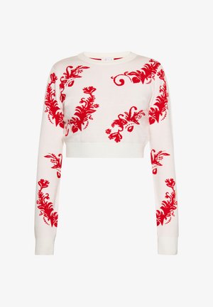Pull court blanc à manches longues avec motifs floraux rouges et ondulations dispersés sur les manches et le devant.