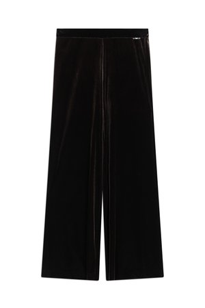 Personne portant un pantalon en velours noir taille haute à jambes larges, des talons pointus marron et un chemisier marron imprimé léopard à manches longues avec un nœud sur le devant.
