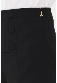 Pantaloni neri a vita alta con una texture liscia, caratterizzati da tre grandi bottoni rotondi e un piccolo dettaglio con zip dorata.