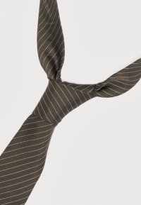 Σκούρα ελιά πράσινη γραβάτα με λεπτές λευκές διαγώνιες ρίγες, δεμένη σε χαλαρό κόμπο σε ανοιχτό φόντο.